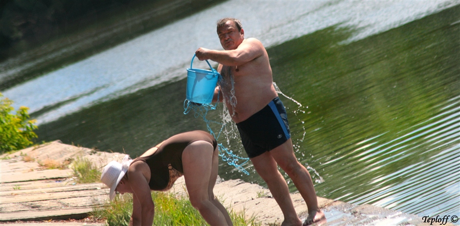 Голая женщина выжимает трусы после бассейна