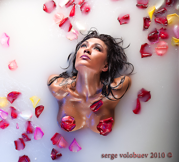 Лепестки роз лежат на голом теле молодой дамы