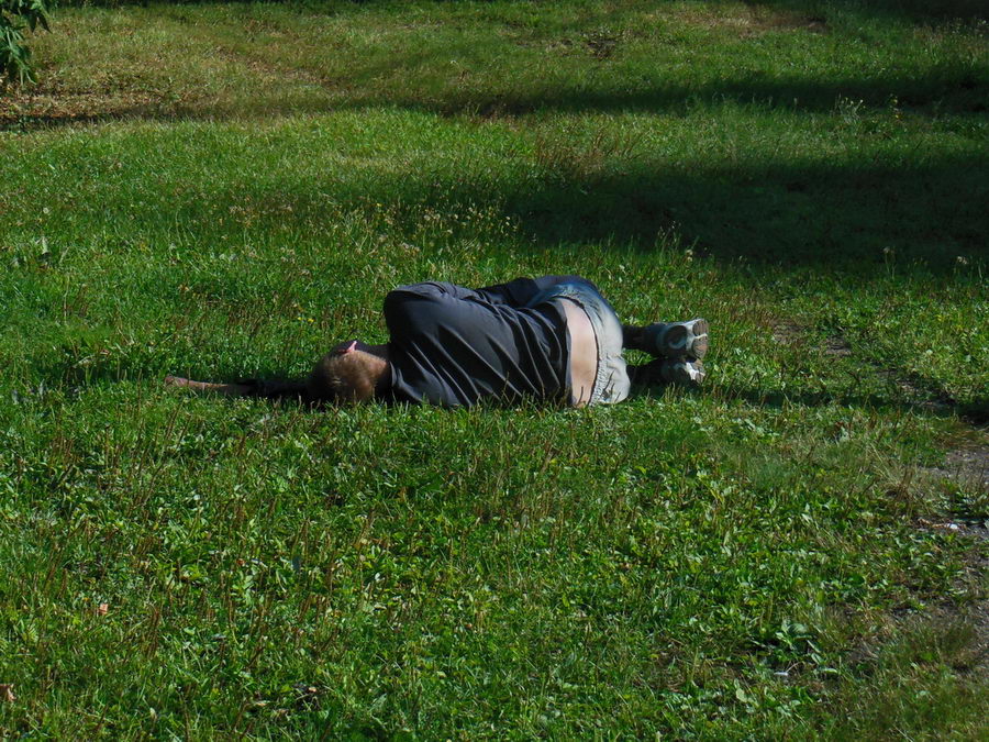 Спящий пьяница. Человекее лежит на земле.
