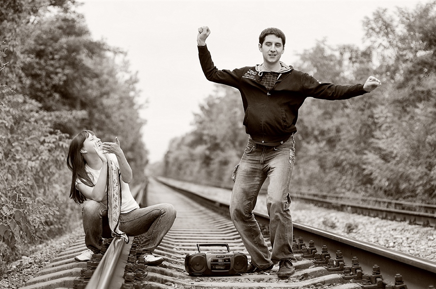 Девушки ходят по мужчине. Гуляет по рельсам. Фотосессия на рельсах. Парень и девушка на рельсах. Парень с девушкой на железной дороге.